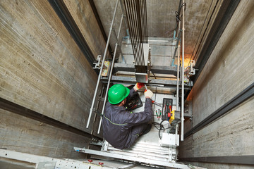 lift machinist repairing elevator in lift shaft