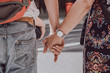 Unidentified Caucasian couple holding hands in public.