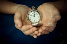 In The Children's Palms The Old Clock. Conceptual Photography. The Time Is 11.55. Five Minutes To Twelve.