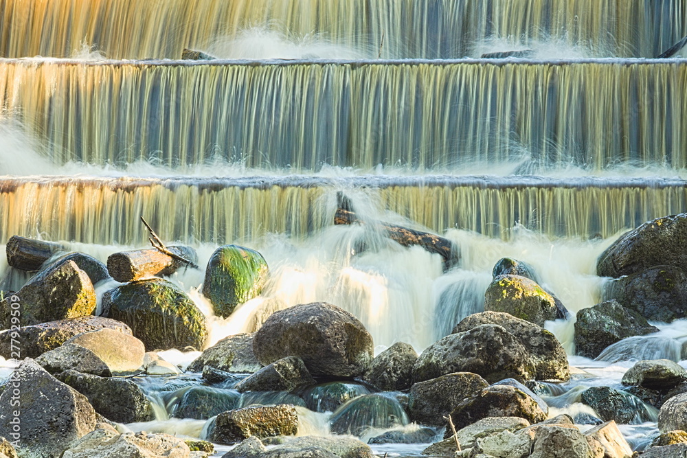 Round Step Waterfall Jets of water flow down the stone steps of an artificial waterfall in ...