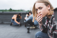 Selective Focus Of Pretty And Blonde Teen Smoking Cigarette And Looking Away