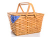 A brown wicker picnic basket on a white background with gingham cloth