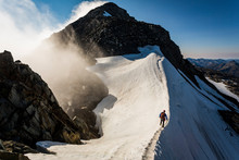 Climber Walking On Snow Ridge Against Mountain