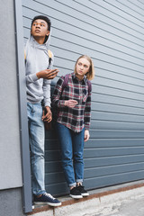 Wall Mural - african american boy and blonde teenager looking away, smoking cigarettes and holding beer