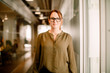 © Maskot - Portrait of female executive wearing eyeglasses and smart casual while standing at work place