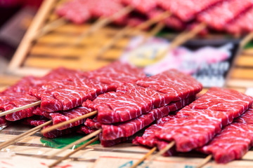 Retail display of skewered wagyu red fat beef on skewer sticks in Tsukiji outer fish street market of Ginza, Tokyo Japan