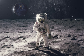 Astronaut on rock surface with space background. Elements of this image furnished by NASA