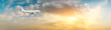 Fototapeta Zachód słońca - Airplane in the sky at sunrise