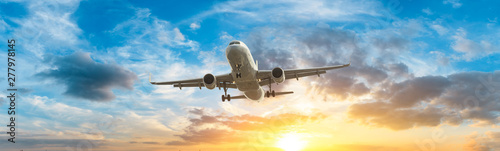 Airplane in the sky at sunrise Fotobehang