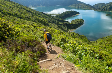 man hiking down to lagoa do fogo or lake of fire in sao miguel, azores, portugal