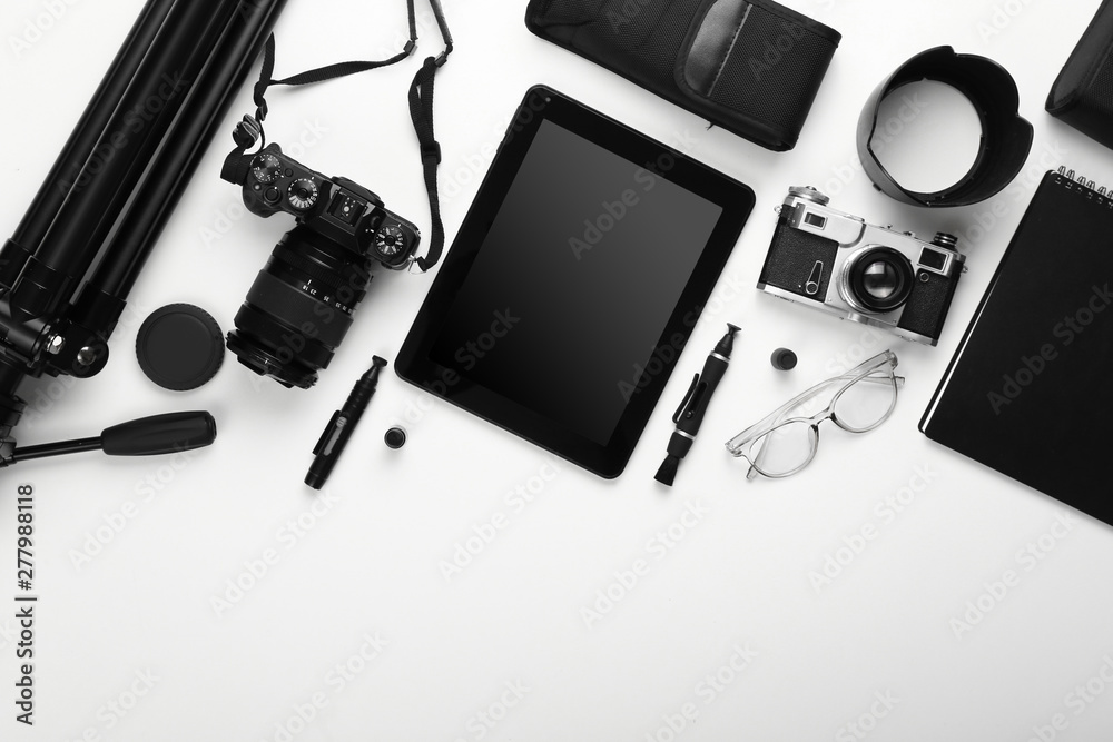 Tablet computer and set of photographer's equipment on white background