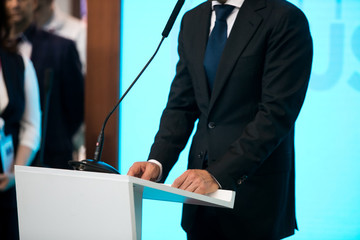 close up of conference meeting microphones and businessman writing