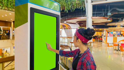 Woman touches a screen of self-ordering kiosk