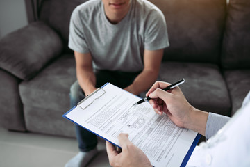 Doctor holding pen is checking the patient condition and is explaining the results of the examination to the patient listening at home.