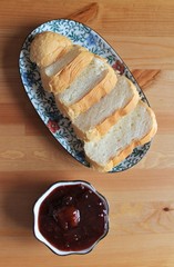 Wall Mural - Slices of white bread on a plate on the table with plum jam