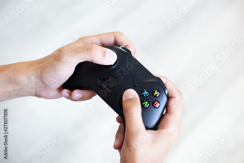 Fotomural Black joystick in hands isolated on white background