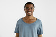 © master1305 - Beautiful male half-length portrait isolated on white studio background. Young emotional african-american man in blue shirt. Facial expression, human emotions, ad concept. Standing, smiling at camera.