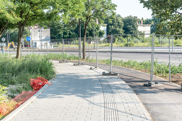 Road work ahead construction site barrier with metal protective fence on the urban street reparation in the city