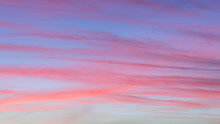Background Of Colorful Beautiful Purple, Magenta And Pink Stripes Of Clouds On Blue Sky At Sunrise