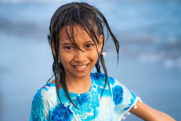 Wall Mural - beach lifestyle portrait of young beautiful and happy 7 or 8 years old Asian American mixed child girl with wet hair enjoying holidays playing in the sea having fun