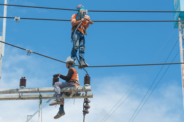 Electricians repairing,electricians repairing wire on electric power pole, power linesman climb the pole.It's a dangerous job.