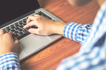 Poster - Businessman wearing a blue plaid shirt working at a computer. Business Concept.