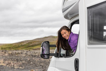 RV Camper Trailer Travel Woman Driving Motorhome Camping Van On Iceland Road Trip. Asian Tourist Driver Smiling Peeking Out Window Of Front Seat