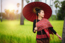 A Beautiful Woman With A Red Umbrella In The Rice Fields Of Greenery, Thailand