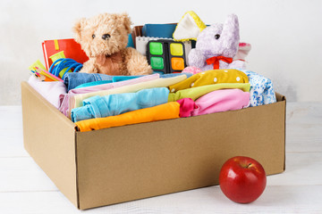 Colorful casual clothes, stationery and toys in a box.