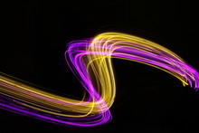 Long Exposure Light Painting Photography, Curvy Lines Of Vibrant Neon Pink Purple And Metallic Yellow Gold Against A Black Background