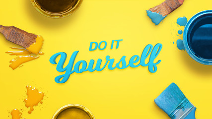 Aufkleber - Do it yourself text surrounded with color brushes and boxes and a few drops of color on yellow surface.