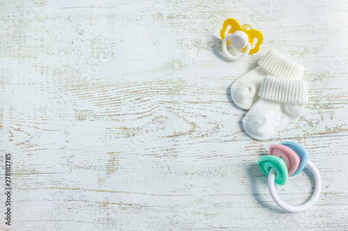 Baby accessories for newborns: socks, toy and soother on light wooden background Slika na platnu
