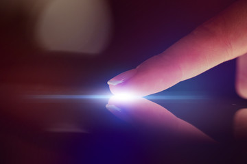 Poster - Finger touching tablet with dark background with copyspace