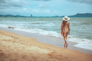 Wall Mural - Travel woman walking on beach