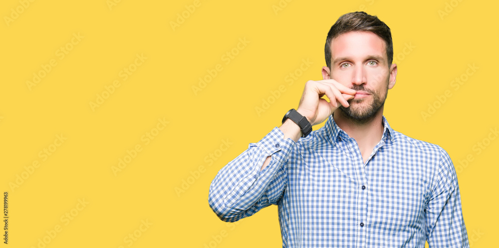 Handsome business man with blue eyes mouth and lips shut as zip with fingers. Secret and silent, taboo talking