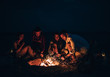 © qunica.com - Friends were sitting around the fire while drinking beer and playing guitar