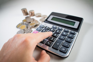 Poster - Man's hand is calculating many Thai coins with calculator. Asia, Thailand.