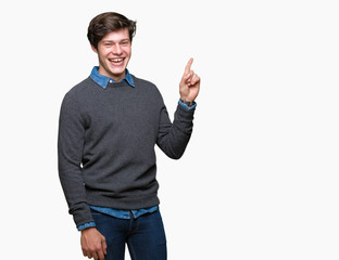 Young handsome elegant man over isolated background with a big smile on face, pointing with hand and finger to the side looking at the camera.