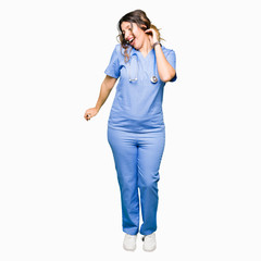 Young adult doctor woman wearing medical uniform Dancing happy and cheerful, smiling moving casual and confident listening to music