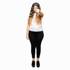 Sticker - Young beautiful woman wearing casual white t-shirt looking unhappy and angry showing rejection and negative with thumbs down gesture. Bad expression.