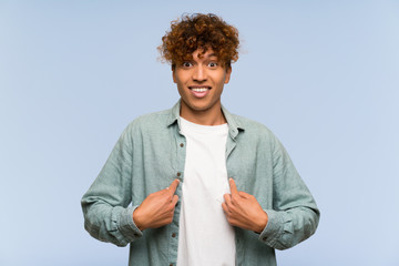 Wall Mural - Young african american man over isolated blue wall with surprise facial expression