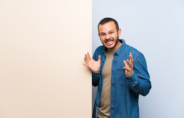 Colombian man holding an empty placard unhappy and frustrated with something