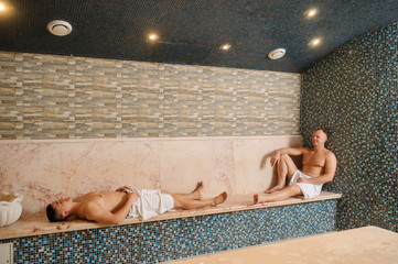 close up photo of two men relaxing in hamam in a spa centre