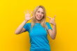 © luismolinero - Young blonde woman over isolated yellow background counting seven with fingers