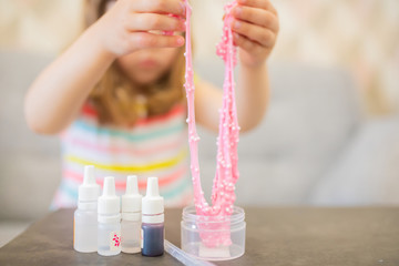 Adorable little girl making slime closeup photo