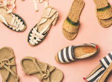 Variety Of Trendy Woman's Summer Shoes. Flat-lay Of Espadrilles, Sandals, Flip Flops Made Of Natural Materials Over Pastel Pink Background, Top View. Summer Season Footwear Apparel Concept
