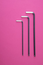Three Allen Wrenches Sorted By Size On Pink