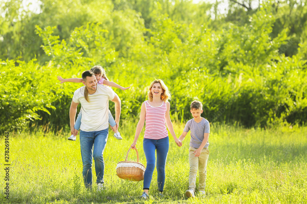 Happy family walking in park on summer day
