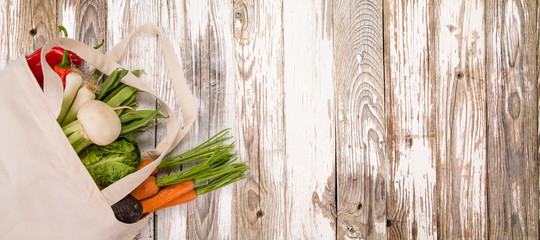 Fresh vegetables in bio eco cotton bags on old wooden table. Zero waste shopping concept. Plastic free. Lots of copy space.