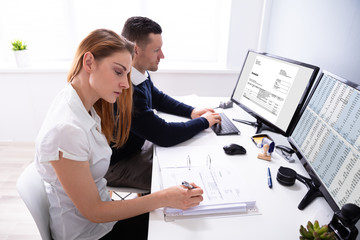 Auditors Working On Computer With Invoice